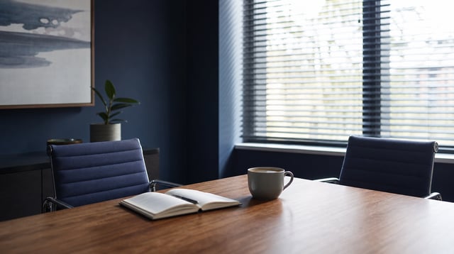 Advisory office conference table with notebook and coffee in morning light