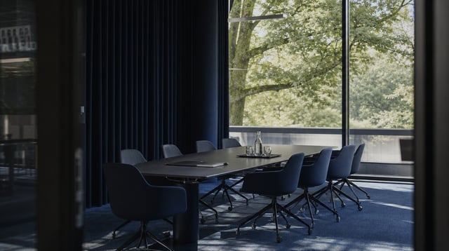 Modern conference room with long table and glass wall in calm blue tones